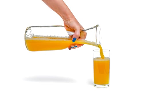 Orange juice isolate. A woman pours orange juice into a glass. Juice filling process on white background, isolated space for design or text insertion.