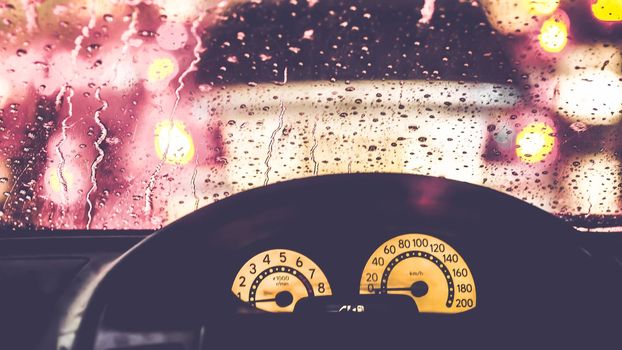 Interior of car when rains. Defocused blur of light on the road in a raining day