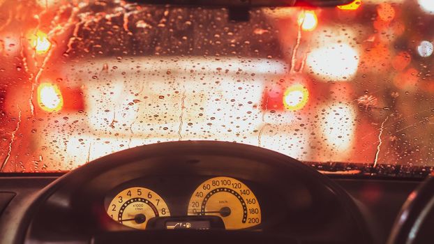 Interior of car when rains. Defocused blur of light on the road in a raining day
