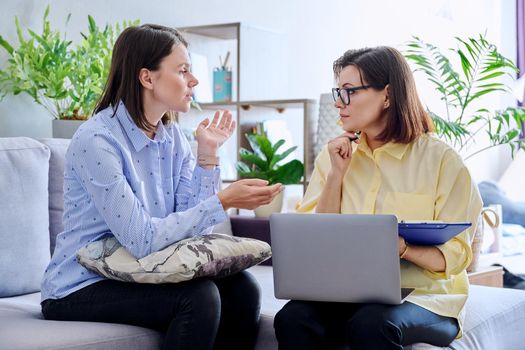 Young woman patient on individual therapy in psychologists office. Mature female concellor listening taking notes talking. Psychology, psychiatry, treatment, mental health concept