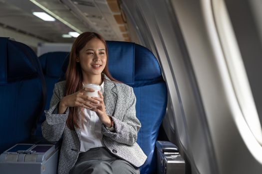 Young asian woman looking at the window in air plane, travel and transport concept.