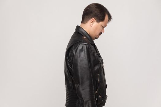 Side view man with mustache, unhappy and crying adult man and looking down. Studio shot