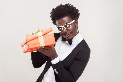 What is inside? Well dressed cunning man looking inside box. Indoor shot