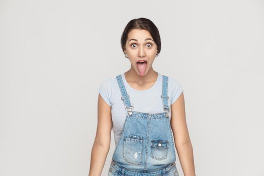 Happiness asian woman with big eyes and tongue out. Indoor shot on gray background studio shot