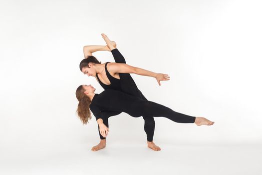 Two flexibility friends dancing, doing performance. Studio shot, isolated on white background