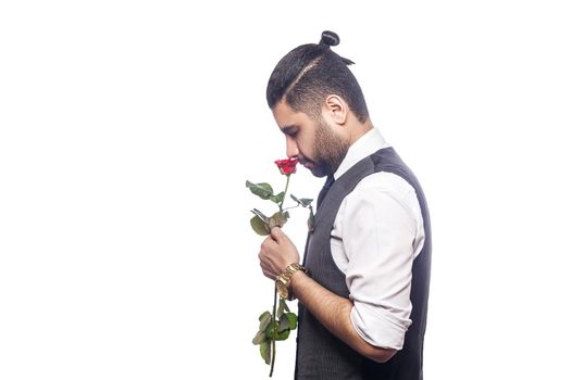 Handsome romantic happy man with rose flower. studio shot. isolated on white background. holding and smelling flower with positive emotion.