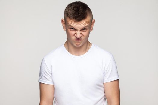 Crazy boy grimacing at camera. Studio shot