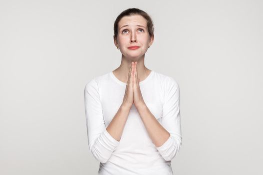 Religion concept. Prayer girl. Studio shot,isolated on gray background