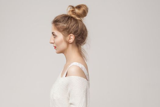 Profile side mixed race blonde woman looking away. Studio shot