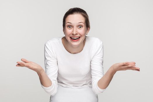 Funny woman looking at camera with shocked face. Studio shot,isolated on gray background