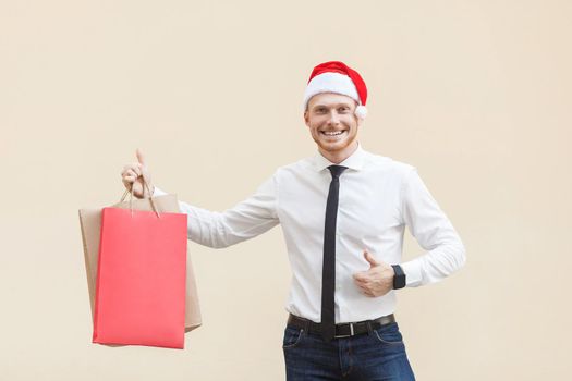 Winter sales. Ginger funny businessman thumbs up and looking at camera with toothy smile. Outdoor shot