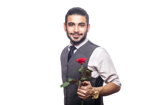 Handsome romantic happy man with rose flower. studio shot. isolated on white background. holding and giving flower and looking at camera and smiling..