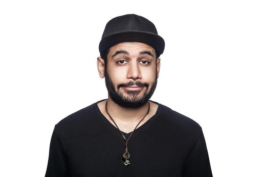 Portrait of young sad unhappy man with black t-shirt and cap looking at camera. studio shot, isolated on white background.