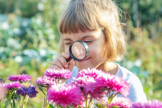 Child with a magnifying glass in his hands. Selective focus.