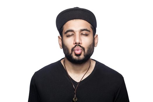 Portrait of young man with black t-shirt and cap kissing with closed eyes. studio shot, isolated on white background.