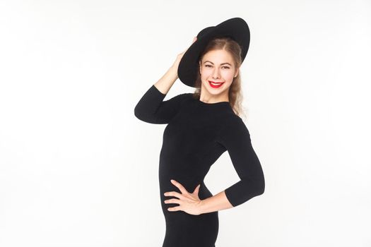 Happiness beautiful woman in hat, black overall posing at camera. Studio shot, isolated on white background