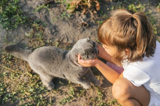 Child girl loves a cat. Selective focus. nature.