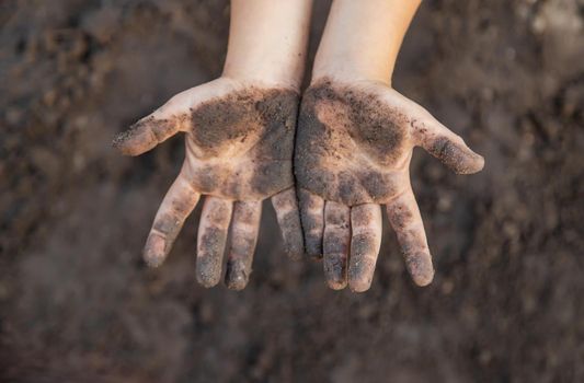 Child in the garden with the earth in his hands. Selective focus. nature.