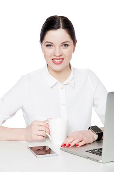 Portrait of attractive happy successful brunette businesswoman with makeup in white shirt sitting, looking at camera with toothy smile and happiness. indoor studio shot, isolated in white background.
