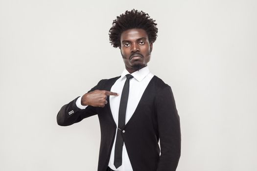 Well dressed proud man looking at camera with chesty face. Studio shot, gray background