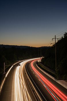 long exposure of highway in Swizerland with hills in the background. Picture made during sunset