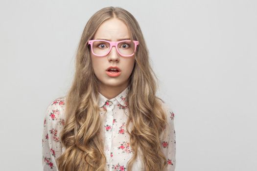 Fear concept. Teenager girl, looking at camera, with surprised face. Studio shot, isolated on gray background