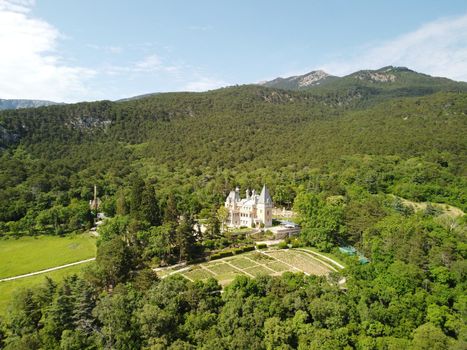 Aerial approach to famous imperial Massandra Palace travel beat landmark Crimea Yalta Russia Ukraine. Beautiful travel sight. Summer green park museum. Renaissance architectural monument. Manor castle