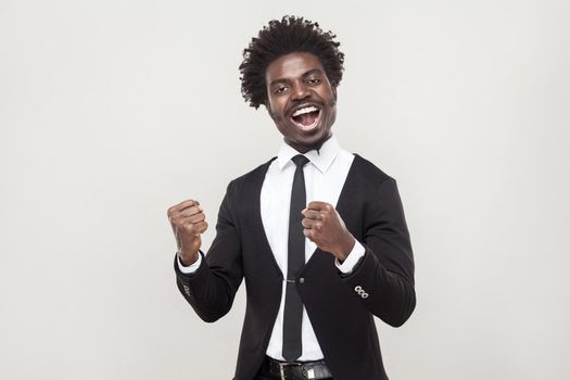 Optimistic african man rejoicing new contract. Studio shot, gray background