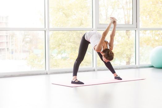 Woman tilt down, doing fitness exercise. Studio shot