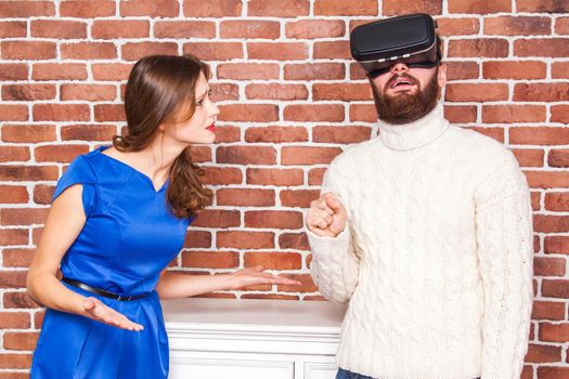 VR technology and conflict between couple. man using vr headset and his wife is angry.