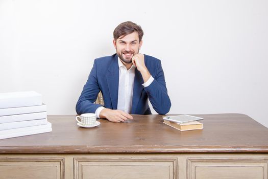 Technology, people and business concept - handsome man with beard and brown hair and blue suit and tablet pc computer and some books looking at camera with smile in the office. .Isolated on white background. .