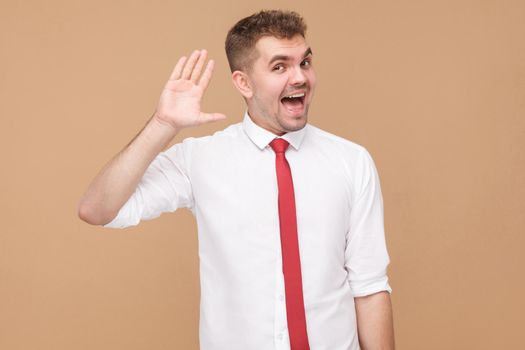 Happy businessman showing hi, hello sign. Business people concept, good and bad emotion and feelings. Studio shot, isolated on light brown background