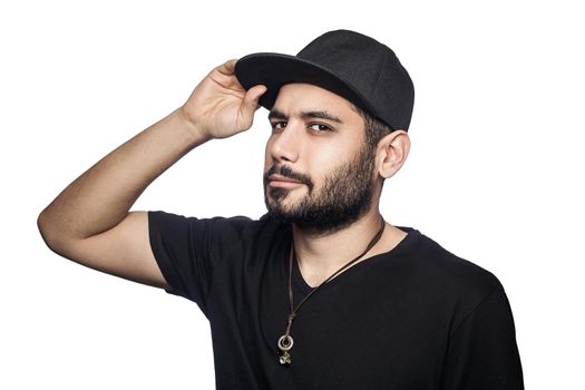 Portrait of young beautiful sexy man with black t-shirt and cap posing and looking at camera. studio shot, isolated on white background.