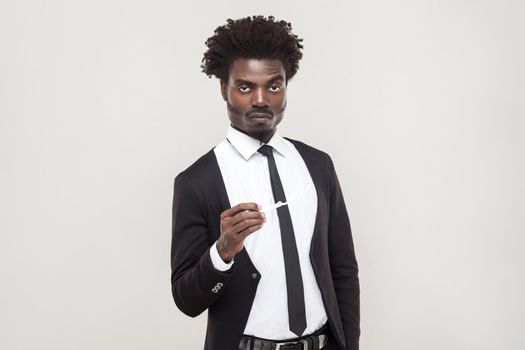 Seriously afro businessman looking at camera and wait. Studio shot