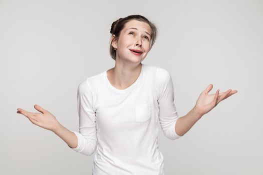 Why me?No! Confused young woman. Studio shot, isolated on gray background