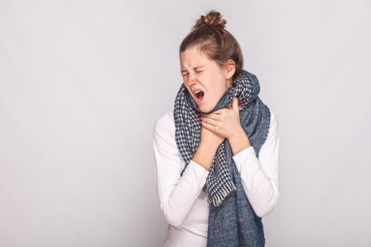 Young adult sick woman touching her neck, have cough, sore throat. Studio shot