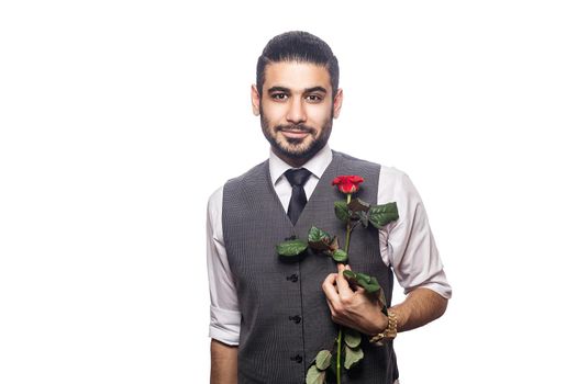 Handsome romantic happy man with rose flower. studio shot. isolated on white background. holding and giving flower and looking at camera and smiling..