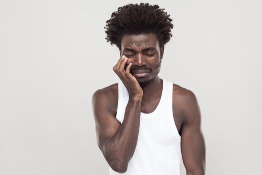 Closed eyes and cry. Unhappy afro man with souvarov mustache, cry and have depression. Indoor shot