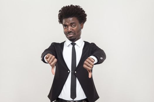 Sadness afro man showing dislike and looking at camera. Studio shot, gray background