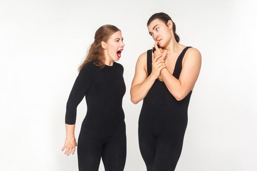 Woman angry and roar at man. Man have a funny look. Studio shot, isolated on white background