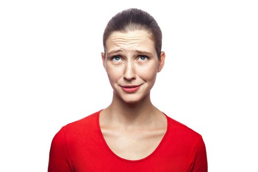 Portrait of sad unhappy woman in red t-shirt with freckles. studio shot. isolated on white background. .