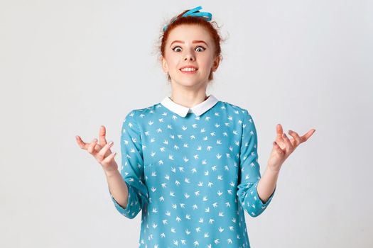 Body language. The young surprised and astonished caucasian girl gesturing in full disbelief, shrugging her shoulders, having shocked expression, opening mouth widely.