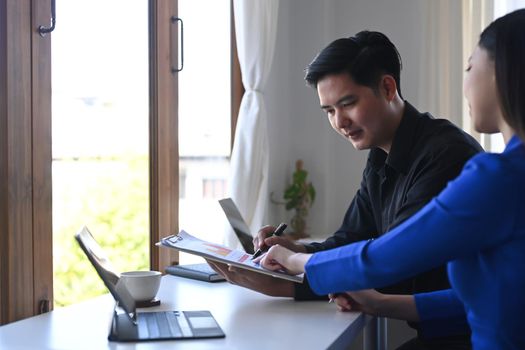 Business people working with financial graphs and statistics documents at office.