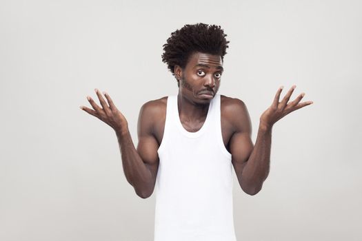 Emotional afro man have a confused look. Studio shot. Gray background