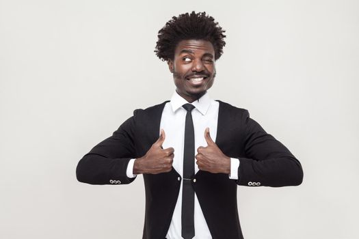 Happiness businessman looking at camera and thumbs up. Studio shot, gray background