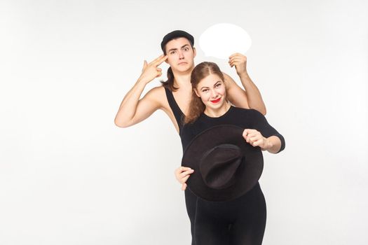 Traffic rules. Couple driving a car, man showing gun sign. Studio shot, isolated on white background