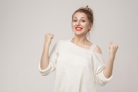 successful and optimistic woman rejoicing her victory. Studio shot