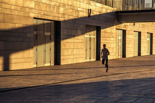 Aged sportsman running on country road, healthy inspirational fitness lifestyle, sport motivation speed interval training. Runner jogging training and doing workout exercising power walking outdoors in city.