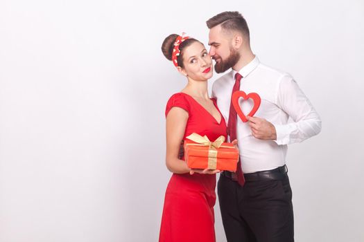 Man present gift box his love in valentine's day. Indoor, studio shot, isolated on gray background