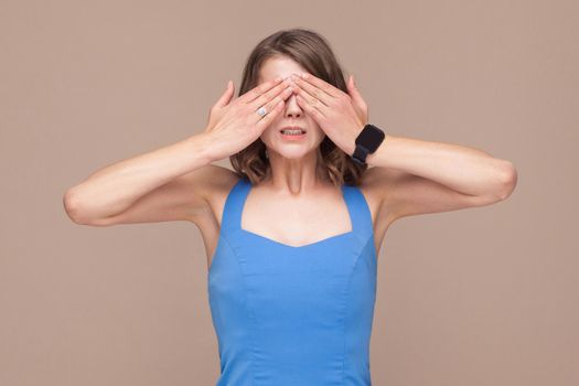 Not interesting. Woman in blue dress closed eyes her hands. Indoor shot